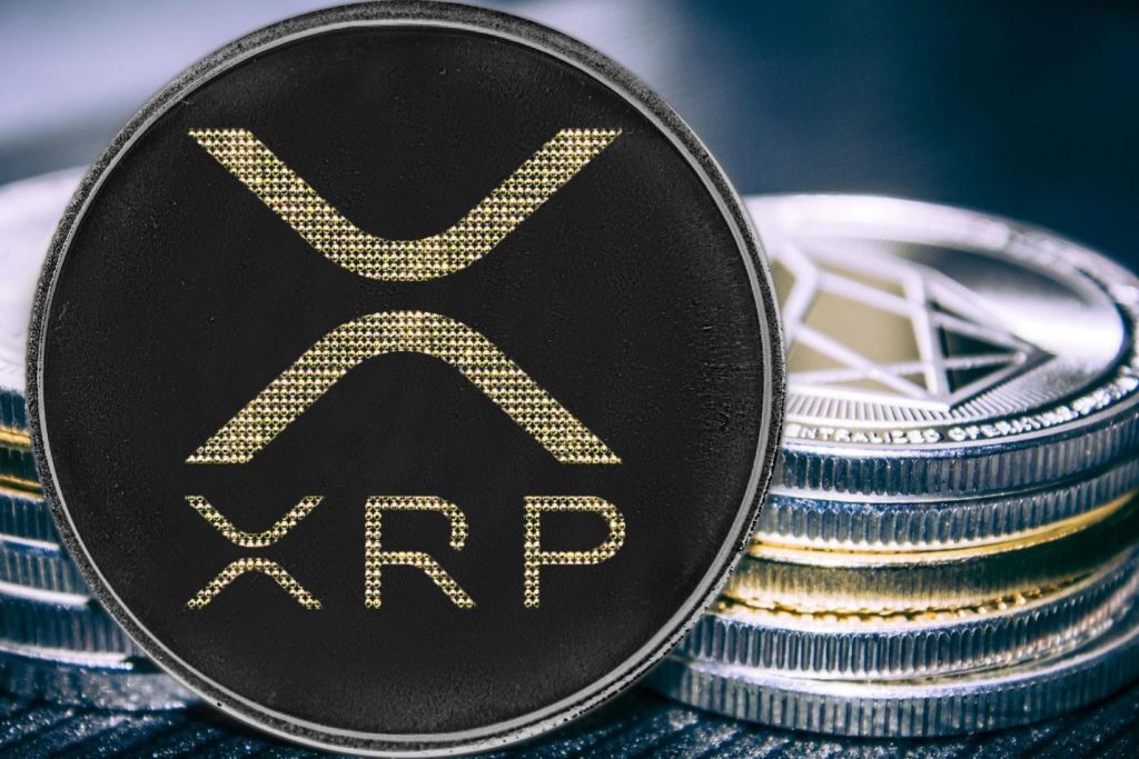 سکه فیزیکی XRP مشکی با حکاکی طلایی، جلوی چند سکه نقره ای دیگر