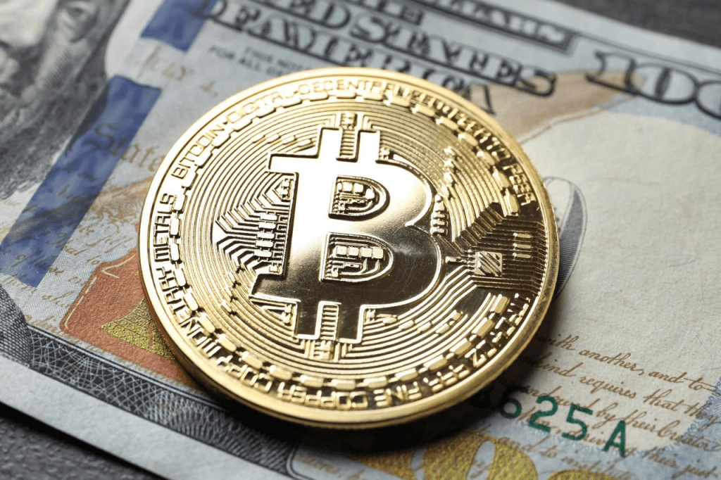 سکه نمادین بیت کوین روی اسکناس دلار، تصویر رویارویی پول دیجیتال با پول رایج